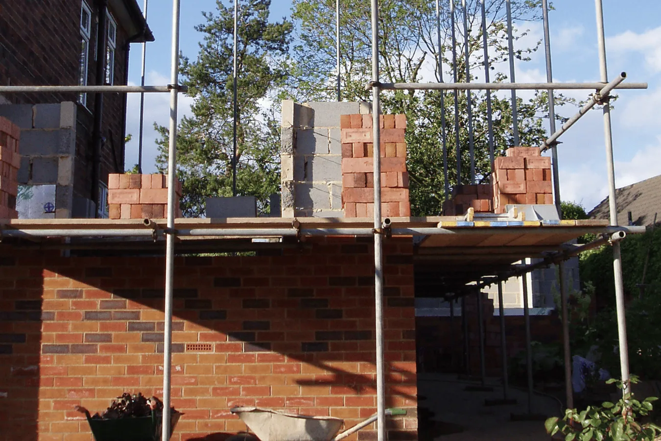 House extension under construction with scaffolding and brickwork