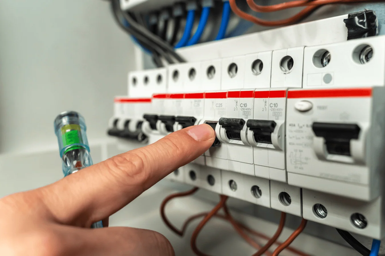 Electrician working on a consumer unit and electrical wiring