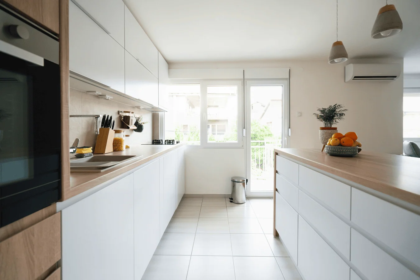 Modern fitted kitchen with white cabinets and wooden worktops